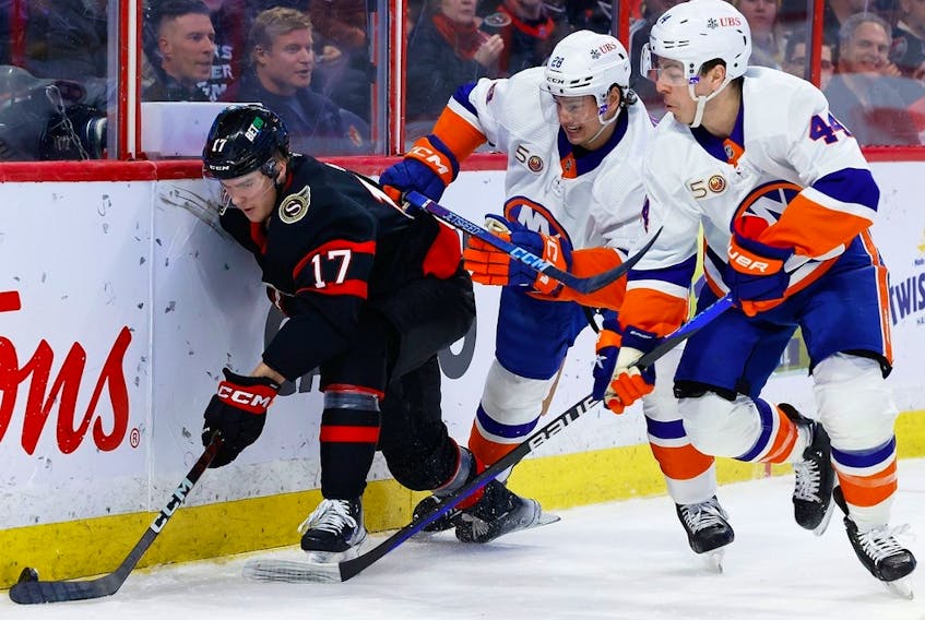 The Ottawa Senators' Ridly Greig (17) keeps the puck away from New York Islanders defenceman Alexander Romanov (28) and centre Jean-Gabriel Pageau (44) during the first period at the Canadian Tire Centre on Wednesday, Jan. 25, 2023. 