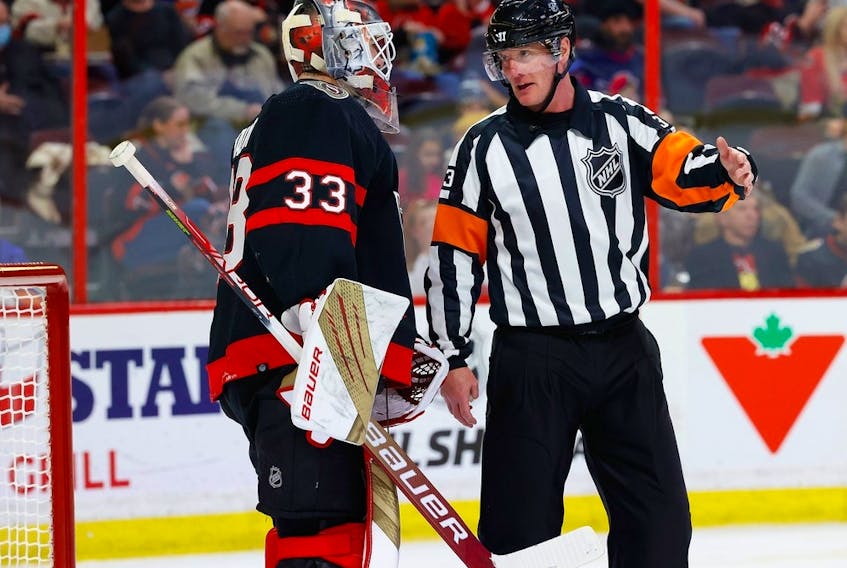  Referee Kevin Pollock explains to Ottawa Senators goaltender Cam Talbot during a stoppage in play why no penalty was called when Talbot was interfered with during the second period against the New York Islanders at the Canadian Tire Centre on Wednesday, Jan. 25, 2023. Talbot left the game with an injury.