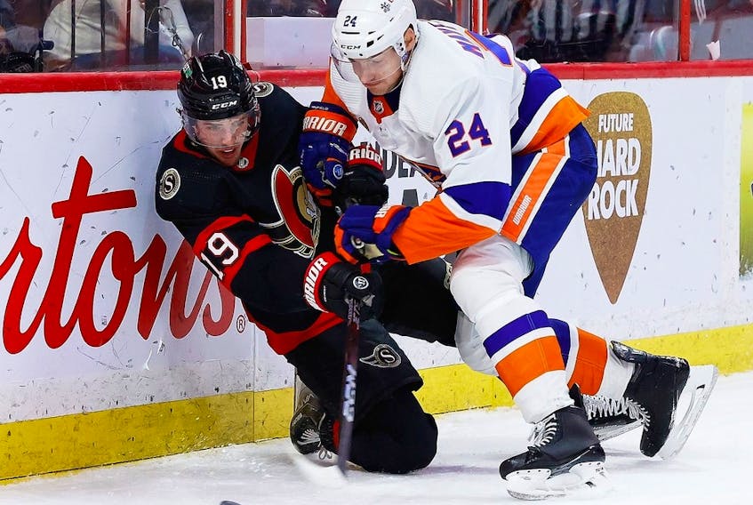  Ottawa Senators right wing Drake Batherson passes the puck from his knee as New York Islanders defenceman Scott Mayfield checks him into the boards during the third period.