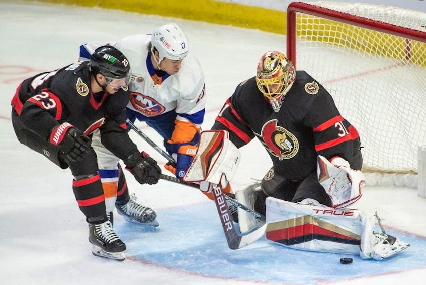 Ottawa Senators goalie Anton Forsberg (31) makes a save in front of New York Islanders left wing Matt Martin (17) in the third period at the Canadian Tire Centre. 