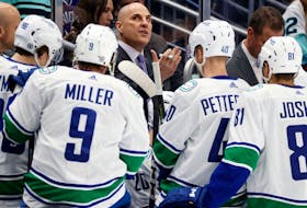 Head coach Rick Tocchet of the Vancouver Canucks gathers his team during the first period against the Seattle Kraken at Climate Pledge Arena on Wednesday in Seattle.