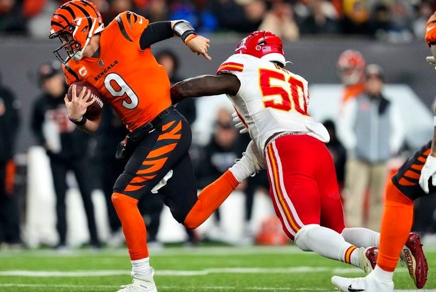 Cincinnati Bengals quarterback Joe Burrow breaks a tackle by Kansas City Chiefs linebacker Willie Gay on a run in the third quarter of a Week 13 NFL game at Paycor Stadium. 