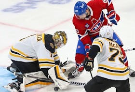 Boston Bruins goaltender Jeremy Swayman stops Montreal Canadiens' Alex Belzile as Charlie McAvoy defends during third period in Montreal on Jan. 24, 2023.