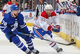 Owen Beck of the Montreal Canadiens flips the puck away against T.J. Brodie of the Toronto Maple Leafs during pre-season game at Scotiabank Arena on Sept. 28, 2022 in Toronto.