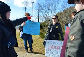 'Silent' protest organizer Kate Munro, left, provides instructions to student Navy Nguyen, centre, and others for Monday's event at Cape Breton University. IAN NATHANSON/CAPE BRETON POST