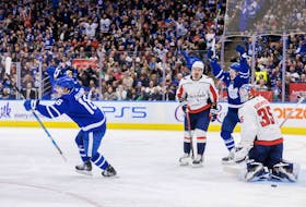 Maple Leafs' Mitch Marner (left) and Michael Bunting celebrate a goal by teammate Morgan Rielly, not shown, as Washington Capitals goaltender Darcy Kuemper looks on during the second period in Toronto on Sunday, Jan. 29, 2023. 