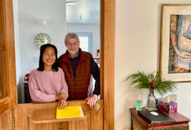 Amone Sayaphong and Alan Riley stand at the reception area of their home-based business, The Rice Bowl.