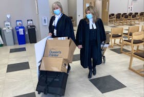 Crown attorneys Kim McOnie, left, and Carla Ball wheel their files out of Nova Scotia Supreme Court in Dartmouth on Tuesday. They are prosecuting William Michael Sandeson on a charge of first-degree murder.