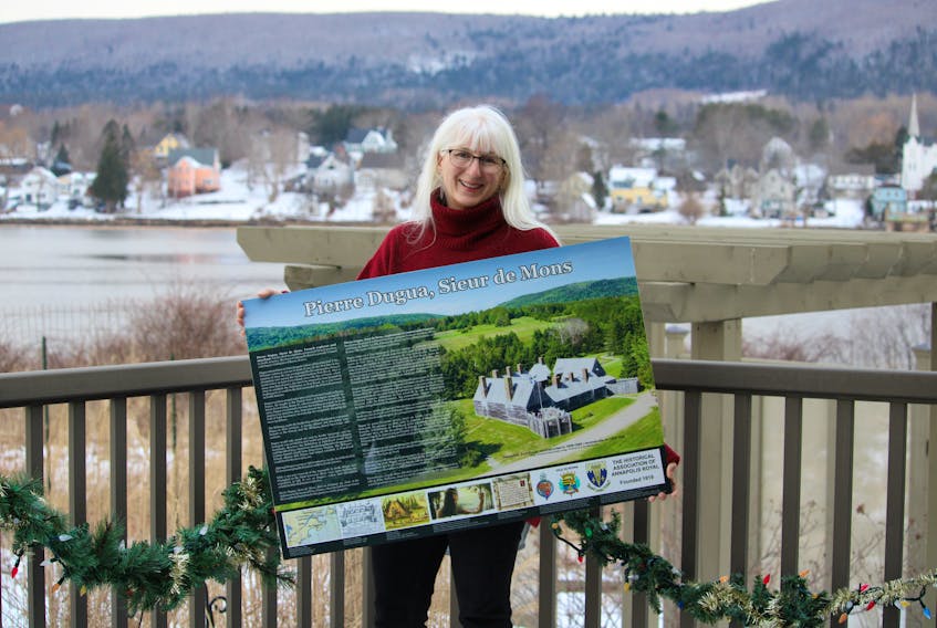 Christine Igot, chairperson of Annapolis Royal’s twinning committee, proudly holds the new interpretative panel that will be installed behind the Oqwa’titek Amphitheatre along the town’s boardwalk in June.  It was funded by The Historical Association of Annapolis Royal.
Jason Malloy