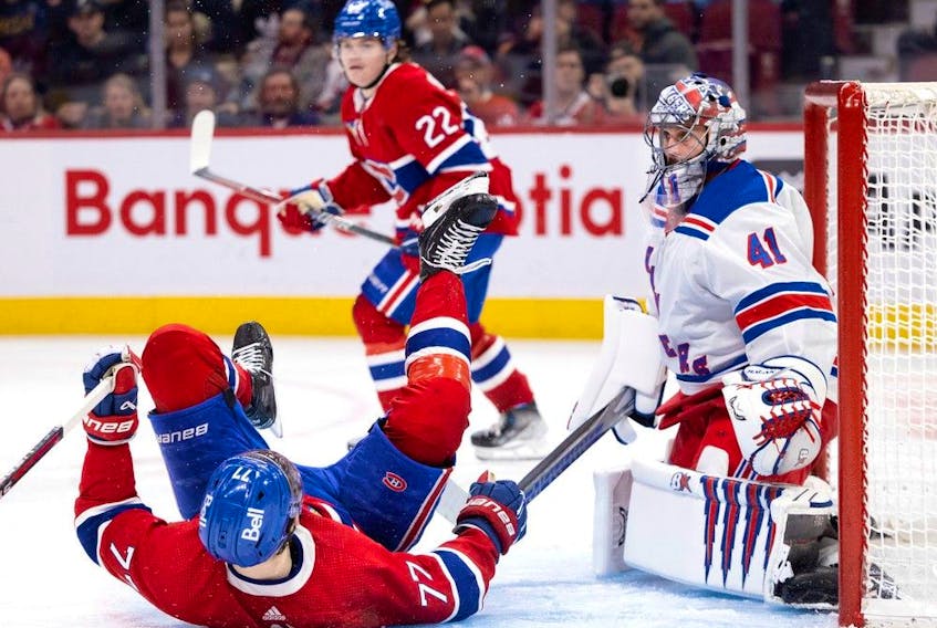 Rangers goaltender Jaroslav Halak looks past Canadiens' Kirby Dach, who was upended in the crease, while Cole Caufield looks on Thursday night at the Bell Centre.