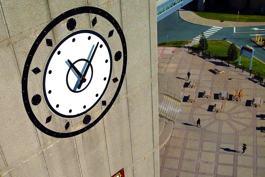 People near the MUN Student Centre walk past the Memorial University clock tower in St. John's. Members of the university's faculty association are meeting Jan. 10 in advance of potentially holding a strike vote. — File photo by Keith Gosse/The Telegram