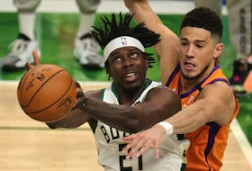 Jrue Holiday, left, of the Milwaukee Bucks is defended by Devin Booker of the Phoenix Suns at the Fiserv Forum on July 14, 2021, in Milwaukee, Wis. Holiday is on the move again this off-season, joining the loaded Boston Celtics in a trade with Portland.