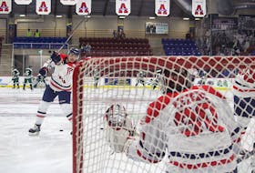 Acadia Axemen forward Liam Kidney warms up goalie Brayden Peters before the team's Sept. 29 pre-season game with the UPEI Panthers. Kidney is a second-year player at Acadia while Peters is in his rookie campaign.