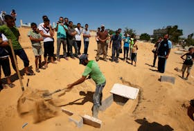 FILE PHOTO: A Palestinian prepares a grave to bury the bodies of the wife of Hamas's military leader, Mohammed Deif, and his infant son Ali, whom medics said were killed in an Israeli air strike, at a cemetery in Beit Lahiya in the northern Gaza Strip August 20, 2014. REUTERS/Mohammed Salem/File Photo