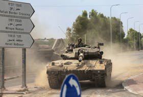 FILE PHOTO: Israeli soldiers drive in a tank by Israel's border with Gaza in southern Israel, October 10, 2023. REUTERS/Ronen Zvulun/File Photo