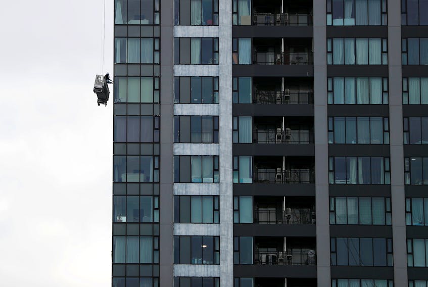 FILE PHOTO: Window cleaners are seen next to a high-rise apartment building in Tokyo, Japan February 12, 2019.  REUTERS/Issei Kato