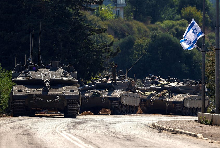 FILE PHOTO: Israeli tanks are seen on a road near Israel's border with Lebanon, in northern Israel, October 12, 2023. REUTERS/Lisi Niesner/File Photo