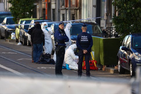 Police officers work outside the site of a police operation against a deadly shooting suspect, in Schaerbeek, Brussels, Belgium, October 17, 2023.