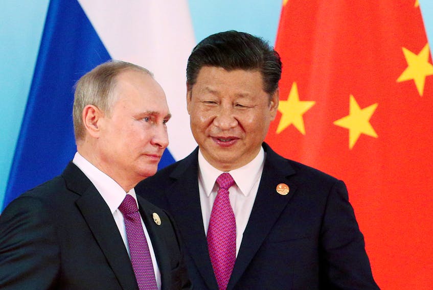FILE PHOTO: Chinese President Xi Jinping (R) stands next to Russian President Vladimir Putin as he arrives for a group photo  during the BRICS Summit at the Xiamen International Conference and Exhibition Center in Xiamen, southeastern China's Fujian Province, China September 4, 2017. REUTERS/Wu Hong/Pool/File Photo