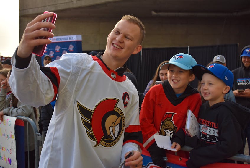 Ottawa Senators captain Brady Tkachuk, left, takes a selfie with 10-year-old Cohen Lynk of Glace Bay, centre, and seven-year-old Kaleb Chisholm of Mira prior to the NHL team’s morning skate at Centre 200 in Sydney. The Senators were in Cape Breton to play the Florida Panthers in NHL pre-season action on Sunday. Tkachuk did not play in the game due to an injury, but made the trip with the team. For more coverage of Kraft Hockeyville, visit saltwire.com/cape-breton. JEREMY FRASER/CAPE BRETON POST