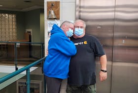 Linda Daigle, left, of Labrador City hugs her husband Shawn after ringing the bell marking the end of her chemotherapy sessions to deal with breast cancer in 2021. - Contributed
