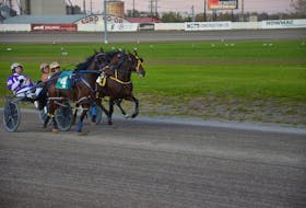 Brodie MacPhee and Dusty Lane Zara, 4, charge to the lead and victory in the opening dash of a 10-race program at Red Shores Racetrack and Casino at the Charlottetown Driving Park on Oct. 19. The Kenny Murphy-driven Model Time, centre, placed while driver and Time And Again, right, finished in the show position. Time of the mile was 1:58.4. Jason Simmonds • The Guardian