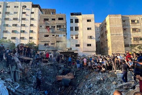 Palestinians gather at the site of an Israeli strike on a house, amid the ongoing conflict between Israel and Palestinian Islamist group Hamas, in Gaza City October 21, 2023.