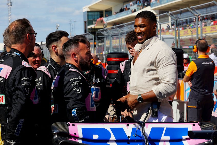 Formula One F1 - United States Grand Prix - Circuit of the Americas, Austin, Texas, U.S. - October 22, 2023 Boxer and Alpine investor, Anthony Joshua with Alpine mechanics on the grid ahead of the race