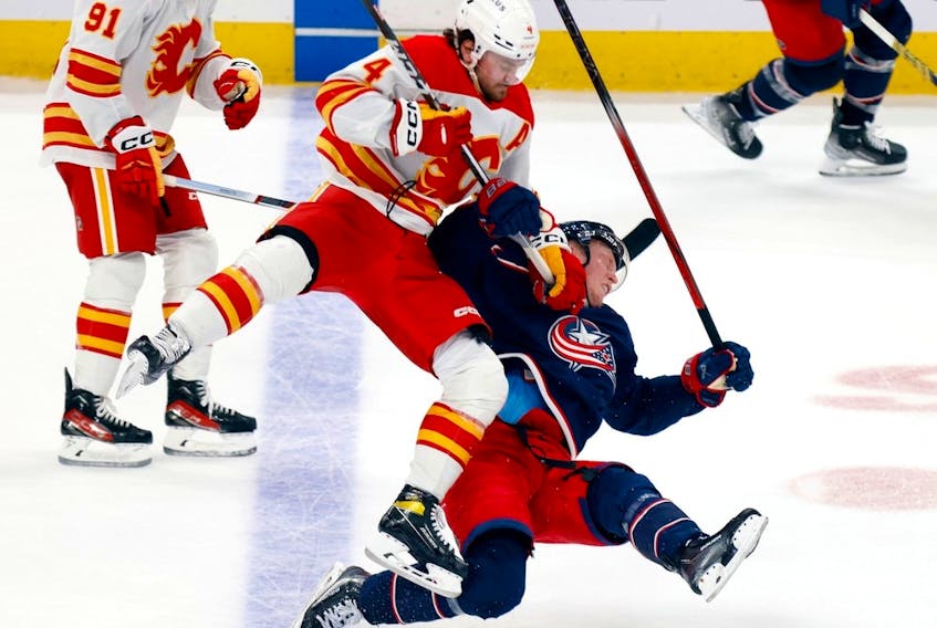 Calgary Flames defenceman Rasmus Andersson checks Columbus Blue Jackets forward Patrik Laine at Nationwide Arena in Columbus, Ohio, on Friday, Oct. 20, 2023.