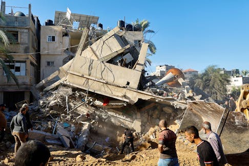 Palestinians search for casualties at the site of an Israeli strike on a house, in Khan Younis, in the southern Gaza Strip, October 21, 2023.