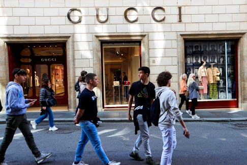 People walk outside a Gucci shop in Rome, April 20, 2023.