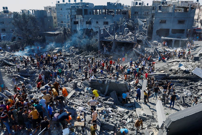 Palestinians search for casualties at the site of Israeli strikes on houses, as the conflict between Israel and Palestinian Islamist group Hamas continues, in Khan Younis in the southern Gaza Strip, October 26, 2023.