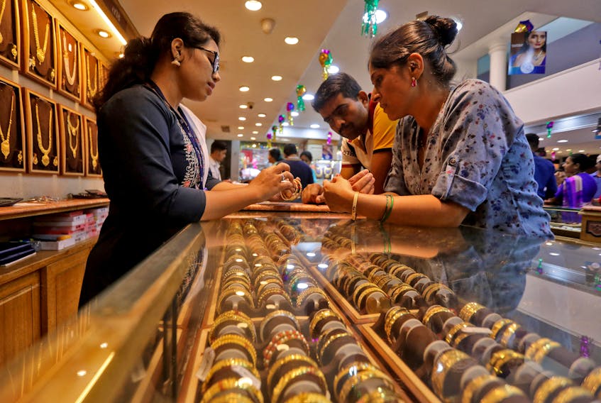 People shop for gold ornaments at a jewellery showroom during Dhanteras, a Hindu festival associated with Lakshmi, the goddess of wealth, in Mumbai, India, October 22, 2022.