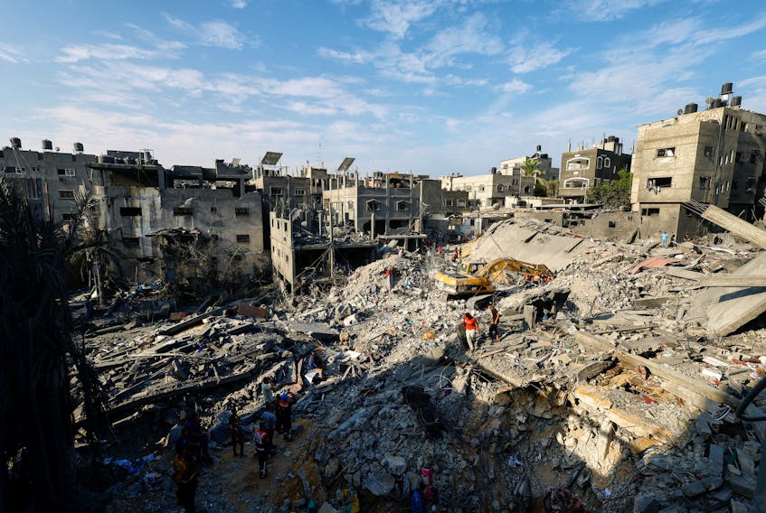 Emergency personnel work at the site of Israeli strikes on houses, as the conflict between Israel and Palestinian Islamist group Hamas continues, in Khan Younis in the southern Gaza Strip, October 27, 2023.