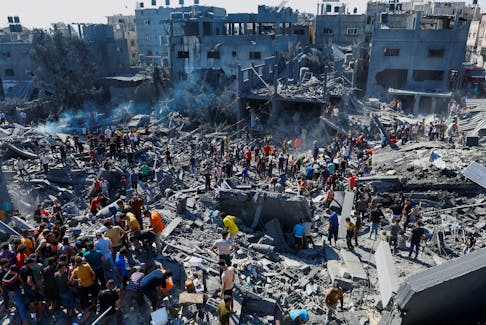 Palestinians search for casualties at the site of Israeli strikes on houses, as the conflict between Israel and Palestinian Islamist group Hamas continues, in Khan Younis in the southern Gaza Strip, October 26, 2023.
