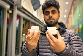 Md Nayeem Shazib shows two sets of counterfeit Apple AirPods Pro, one he purchased and the other belonging to his friend. Even though they bought these from different sellers on Facebook Marketplace, both sets share identical serial numbers. Thinh Nguyen • The Guardian
