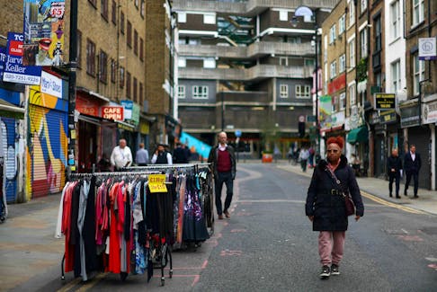 A woman walks past a clothes rail with items for sale in London, Britain, October 23, 2023.