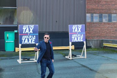 Pierre Poilievre makes a his entrance to a press conference held on October 27 in St. John's, flanked by 'Axe the Tax' signs. - Cameron Kilfoy/The Telegram.