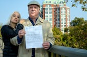  Chris Monk, right, seen here with partner Romina Taheri, holds a bill from Chartwell Rockcliffe Retirement Residence.