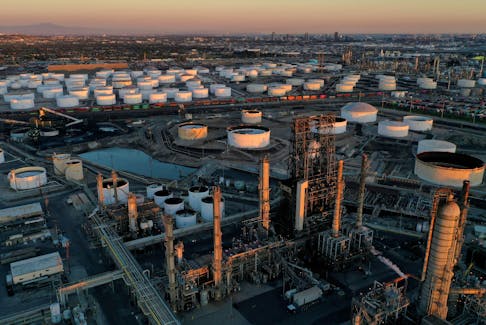 A view of the Phillips 66 Company's Los Angeles Refinery (foreground), which processes domestic & imported crude oil into gasoline, aviation and diesel fuels, and storage tanks for refined petroleum products at the Kinder Morgan Carson Terminal (background), at sunset in Carson, California, U.S., March 11, 2022. Picture taken March 11, 2022. Picture taken with a drone.
