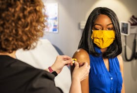 In this 2020 photograph, captured inside a clinical setting, a health care provider and patient, consult on influenza vaccine options. - CDC