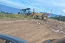 A resident in Meat Cove took a photo of the Nova Scotia Department of Public Works road grader that went off the road in September while doing maintenance on the 8 kilometre stretch of roadway that leads to the village. CONTRIBUTED