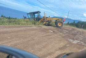 A resident in Meat Cove took a photo of the Nova Scotia Department of Public Works road grader that went off the road in September while doing maintenance on the 8 kilometre stretch of roadway that leads to the village. CONTRIBUTED
