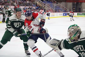 Acadia Axmen forward Cole Nagy, centre, goes hard to the net while being defended by UPEI’s Cameron Morton during pre-season action Sept. 29 in Wolfville.
