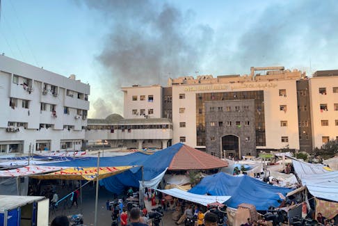 Smoke rises as displaced Palestinians take shelter at Al Shifa hospital, amid the ongoing conflict between Hamas and Israel, in Gaza City, November 8, 2023.