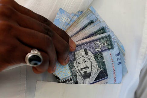 A Saudi man shows Saudi riyal banknotes at a money exchange shop, in Riyadh, Saudi Arabia, January 20, 2016.