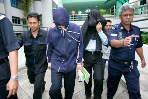 Policemen Azilah Hadri (2nd L) and Sirul Azhar Umar (2nd R) arrive at the courthouse in Shah Alam outside Kuala Lumpur January 15, 2009. Hadri and Umar on Thursday began their defence after being accused of murdering Mongolian Altantuya Shaariibuu.