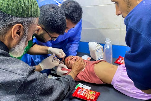 Palestinian girl Orheen Al-Dayah, who was injured in her forehead in an Israeli strike amid the ongoing conflict between Hamas and Israel, has her wounds stitched without anaesthesia, at Al Shifa hospital in Gaza City, November 8, 2023.