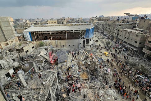 Palestinians inspect the site of Israeli strikes on houses in Jabalia refugee camp, in northern Gaza, November 14, 2023.