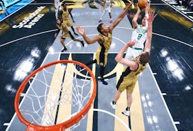 Kristaps Porzingis #8 of the Boston Celtics puts up a shot between Scottie Barnes #4 and Jakob Poeltl #19 of the Toronto Raptors during the second half of their NBA In-Season Tournament game at Scotiabank Arena on November 17, 2023 in Toronto. 